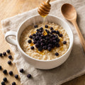 Porridge cald cu afine uscate de pădure și miere — gustare de sezon