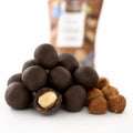 Alune de pădure în ciocolată fără zahăr BIO, 50g — alune de pădure în ciocolată, una tăiată ca să se vadă miezul, și alune crude, Biovicta