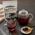 Ceai infuzie de aronia în ibric de sticlă — ritual wellness