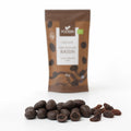 Stafide în ciocolată raw BIO, 80g — stafide învelite în ciocolată, două tăiate ca să se vadă fructul, și stafide simple, cu punga în fundal, Biovicta